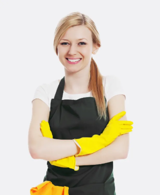 Smiling woman in a white shirt wearing a black apron and yellow rubber gloves with arms crossed, ready to clean.